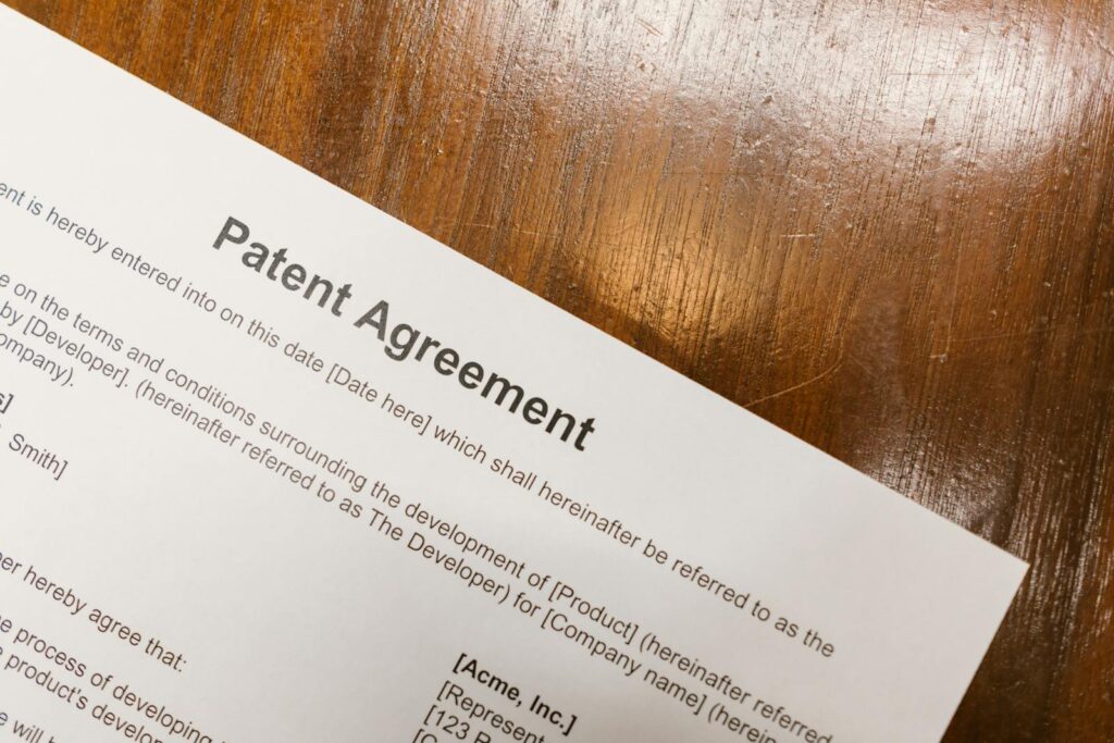 Detailed close-up of a patent agreement document on a polished wooden table.